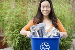 Smiling woman with recycling bin